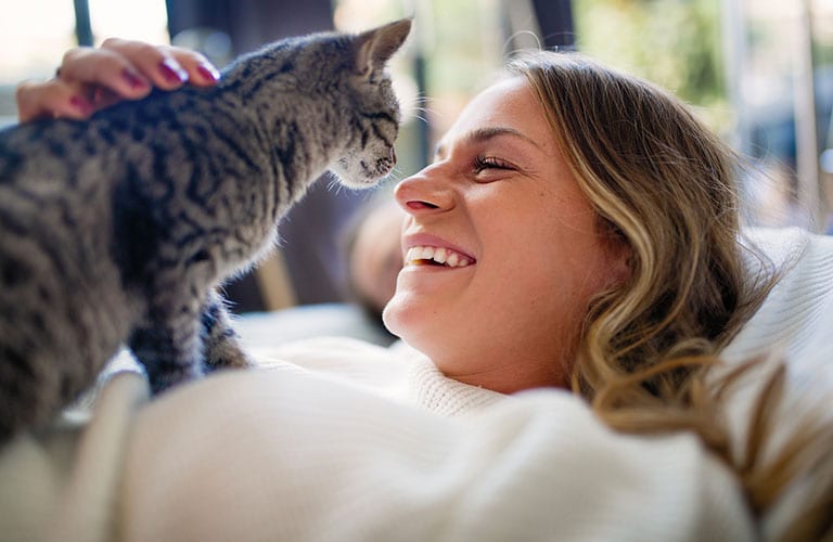 Pet Wellness Care in Cary: Woman Sitting On Couch With Cat